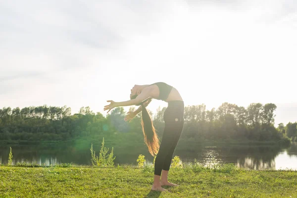 Hälsosam livsstil och människor Concept-flexibel kvinna gör yoga i sommar parken — Stockfoto