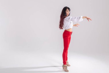 Latin dansı, striptiz dansı, çağdaş ve bachata bayan konsepti - doğaçlama dans eden ve uzun saçlarını beyaz arka planda gezdiren kadın