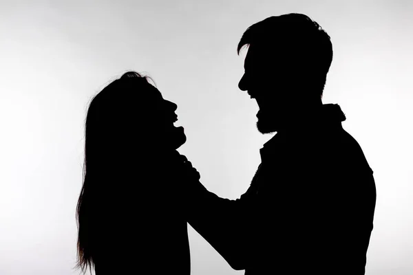 Violência doméstica e conceito de abuso - Silhueta de um homem asfixiando uma mulher — Fotografia de Stock