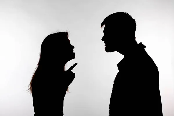 Concetto di aggressione e abuso - uomo e donna che esprimono violenza domestica nella silhouette dello studio isolati su sfondo bianco . — Foto Stock