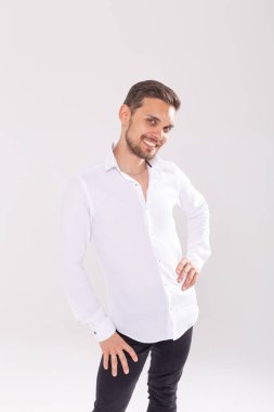 Beyaz arka plan aleyhine duran rahat gömlek yakışıklı mutlu genç adam Portresi
