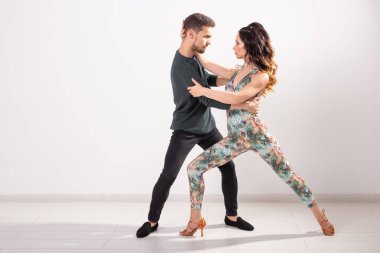 Genç çift sosyal latin dans dans bachata, merengue, salsa. Beyaz arka plan üzerinde iki zerafet poz