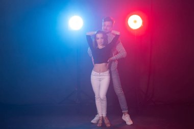 Sosyal dans, bachata, salsa, kizomba, zouk ve tango kavramı - Erkek ışıklar üzerinde dans ederken kadın kucaklar