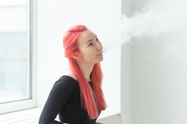 Vape, bağımlılık ve insan kavramı - kızıl saçlı kadın vape sigara