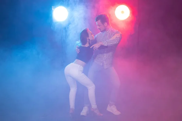 Dança social, bachata, salsa, kizomba, zouk, conceito de tango - Homem abraça mulher enquanto dança sobre luzes — Fotografia de Stock