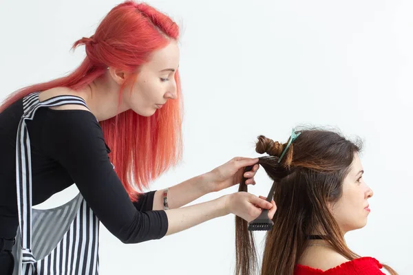 Estilista de cabelo, coloração e conceito de pessoas - cabeleireiro cabelo vermelho colorir jovem mulher na camisa vermelha — Fotografia de Stock