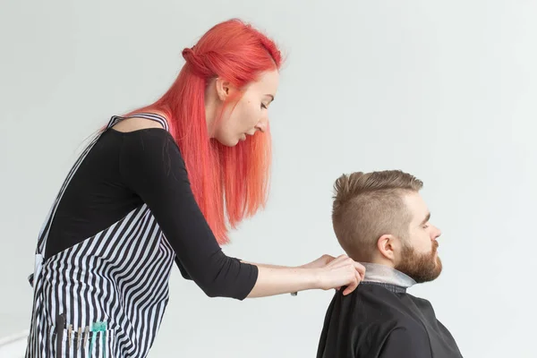 Concepto de peluquería, estilista y peluquería - mujer joven estilista va a cortar a un hombre —  Fotos de Stock