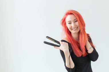 Saç Stilist, kuaför ve insan kavramı - beyaz arka plan üzerinde kıvırma demir tutan renkli saçlı genç kadın