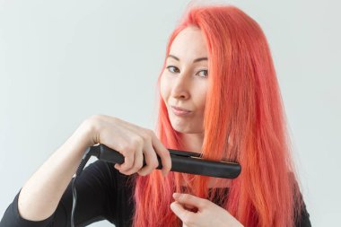 Saç Stilist, kuaför ve insan kavramı - beyaz arka plan üzerinde kıvırma demir tutan renkli saçlı genç kadın