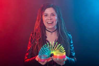 Ufa, Rusya - 3 Nisan 2019 : Elinde gökkuşağı oyuncak tutan gülümseyen büyüleyici genç esmer kadın. Kaygısız genç kız kavramı