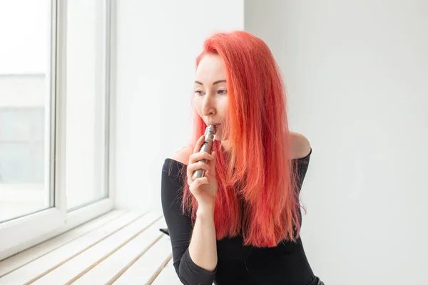 청소년과 중독 개념 - 젊은 빨간 머리 여자 흡연 vape 근처 창 — 스톡 사진