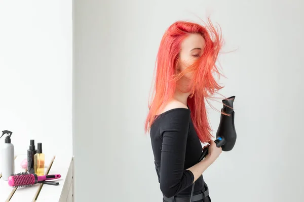 Стилист, мода, парикмахер, люди понятие - женщина сушит свои цветные волосы — стоковое фото