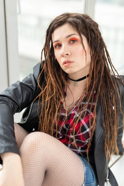 Dreadlocks, coiffeur et concept de style - Une fille drôle avec dreadlocks et en veste en cuir et maquillage à la mode — Photo