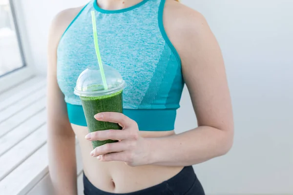 Healthy, sport, diet and people concept - Successful fitness urban woman recommending detox smoothie, close-up