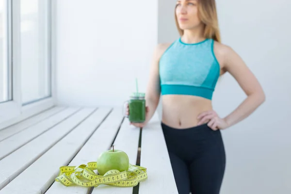 Concetto sano, fitness e disintossicazione - primo piano della giovane donna in abbigliamento sportivo con frullato verde all'interno — Foto Stock