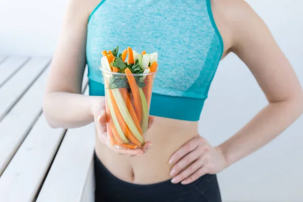 Concetto di dieta - primo piano di donna di stile di vita sana che tiene verdure all'interno. Giovane femmina mangiare cibo sano . — Foto Stock