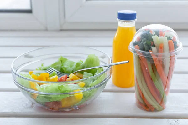 Κύπελλο πράσινης σαλάτας, ωμά λαχανικά και μπουκάλι χυμό πορτοκαλιού. Έννοια απώλειας βάρους, διατροφής και δεξιάς διατροφής — Φωτογραφία Αρχείου