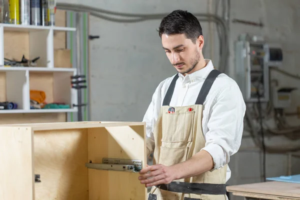 Meubelfabriek, kleine bedrijven en People concept-Young Worker werkt in een fabriek voor de productie van meubelen — Stockfoto