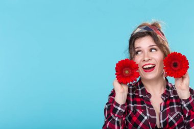 pin-up ve çiçek kavramı - kopya alanı ile mavi arka plan üzerinde gerberas ile güzel genç kadın