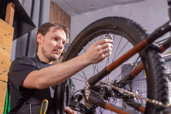 Service, reparatie, fiets en mensen concept-monteur repareren van een mountainbike in een workshop — Stockfoto