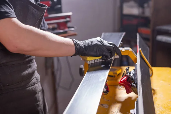 Werk-en reparatie concept-een Mans handen repareren van de ski door het wrijven van een paraffine — Stockfoto