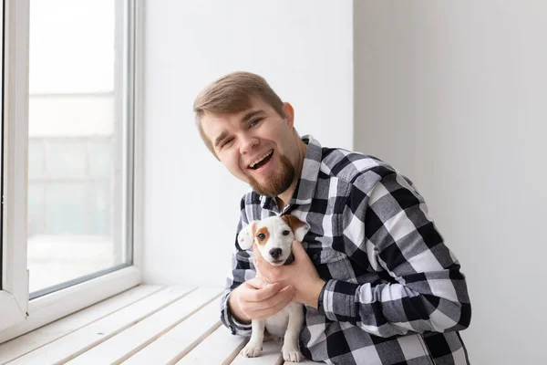 Concepto de personas, mascotas y animales - joven abrazando gato russell terrier cachorro — Foto de Stock