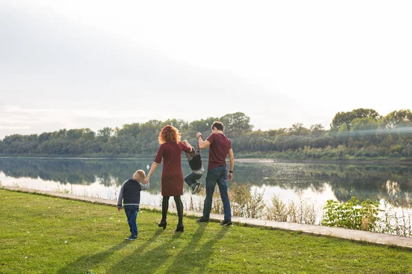 Eltern, Kindheit und Naturkonzept - Familie spielt mit zwei Söhnen am Wasser — Stockfoto