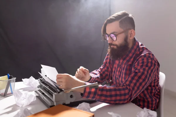 Koncepcja ludzi i technologii - Światowy dzień pisarza, przystojny mężczyzna w okularach, ubrany w koszulę w kratę, praca na maszynie do pisania — Zdjęcie stockowe