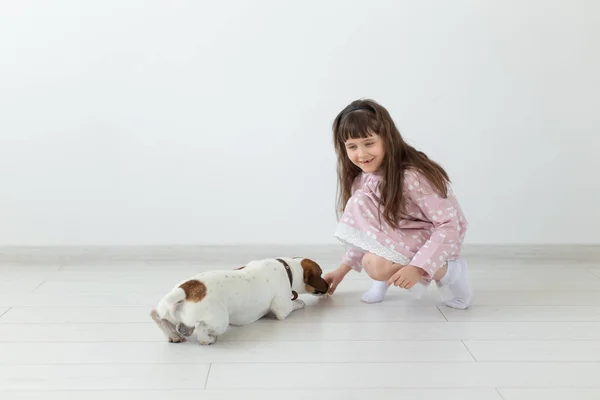 Niña alegre en un vestido azul jugando con su amado perro Jack Russell Terrier. Concepto de amistad de niños y perros. Espacio publicitario — Foto de Stock