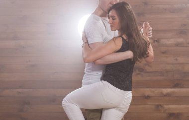 Sosyal dans, bachata, kizomba, tango, salsa, insan kavramı - Kopya alanı ile ahşap arka plan üzerinde dans genç çift Close-up
