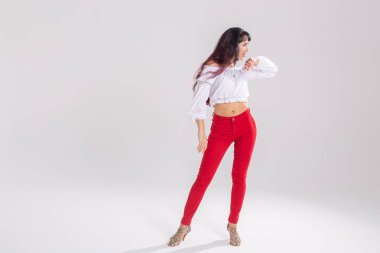 Latin dansı, striptiz dansı, çağdaş ve bachata bayan konsepti - doğaçlama dans eden ve uzun saçlarını beyaz arka planda gezdiren kadın