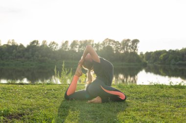 Sağlıklı yaşam tarzı Kavramı - Kız yoga asana açık havada yapıyor.