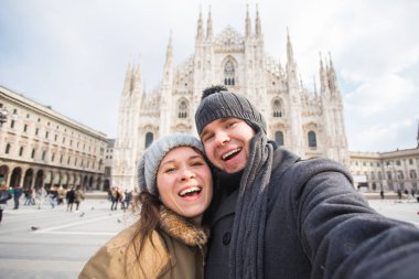 Milano'daki Duomo meydanında kendi portresini çeken çift. Kış seyahati, İtalya ve ilişki konsepti