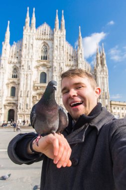 Seyahat, tatil ve kış tatil kavramı - mutlu adamı kabul selfie fotoğraf komik güvercinler ile Duomo Milan Katedrali önünde