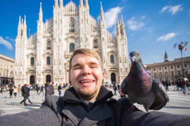 Seyahat, tatil ve kış tatil kavramı - mutlu adamı kabul selfie fotoğraf komik güvercinler ile Duomo Milan Katedrali önünde