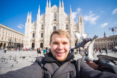 Seyahat, tatil ve kış tatil kavramı - mutlu adamı kabul selfie fotoğraf komik güvercinler ile Duomo Milan Katedrali önünde