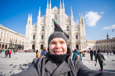 Seyahat, tatil ve kış tatil kavramı - mutlu adamı kabul selfie fotoğraf komik güvercinler ile Duomo Milan Katedrali önünde