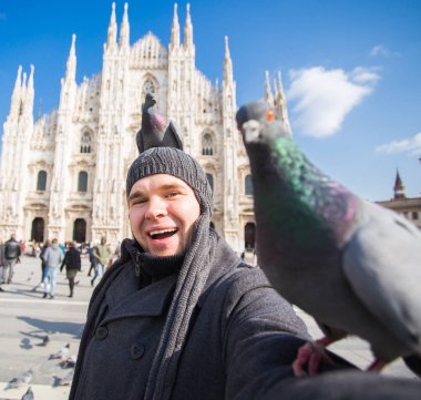 Seyahat, tatil ve kış tatil kavramı - mutlu adamı kabul selfie fotoğraf komik güvercinler ile Duomo Milan Katedrali önünde