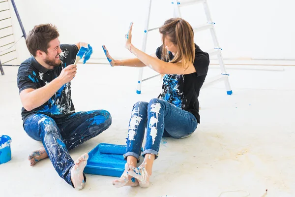 Ridecorazione, colore, ristrutturazione e concetto di persone - coppia che va a dipingere la parete, stanno mescolando il colore e divertirsi — Foto Stock