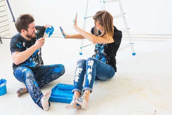 Redecoración, color, renovación y concepto de personas - pareja va a pintar la pared, que están mezclando el color y divertirse — Foto de Stock