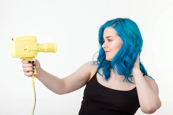 Menschen, Hobby und Modekonzept - schöne Mädchen mit blauen Haaren halten gelbe Retro-Kamera auf weißem Hintergrund — Stockfoto