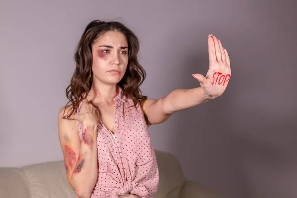 Violenza domestica, protesta e concetto di persone - donna bruna che esprime negazione con STOP sulla mano nella stanza grigia — Foto Stock