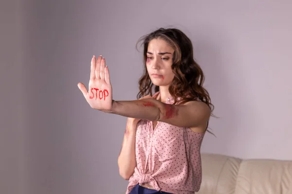 Violenza domestica, protesta e concetto di persone - donna bruna che esprime negazione con STOP sulla mano nella stanza grigia — Foto Stock