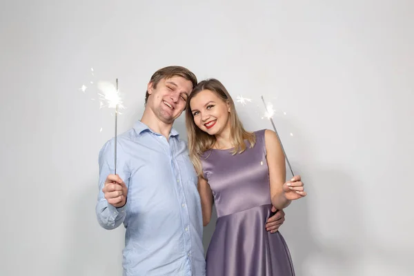 Διακοπές, πάρτι και γιορτές έννοια - νεαρό ζευγάρι με βεγγαλικά σε λευκό φόντο — Φωτογραφία Αρχείου