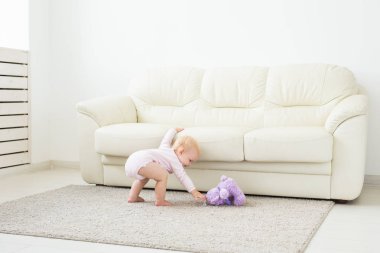 Çocuklar, bebek ve çocukluk konsepti - güzel gülümseyen bebek oynuyor