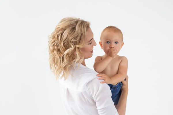 Único pai, maternidade e conceito de infância - Mãe segurando doce bebê menina no fundo branco — Fotografia de Stock