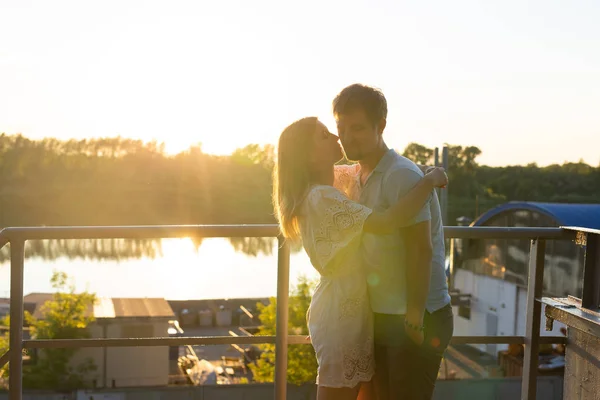 Magnifique jeune couple embrasser et profiter de la vie ainsi que le style de vie naturel de loisirs de plein air sur la nature et le coucher du soleil dans le contre-jour . — Photo