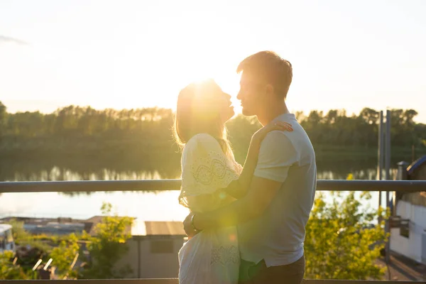 Homme et femme étreignant au coucher du soleil sur la nature. Couple en étreinte romantique — Photo