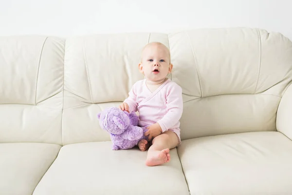 Concepto de niño, infancia y niños - Retrato de la encantadora niña en el sofá — Foto de Stock