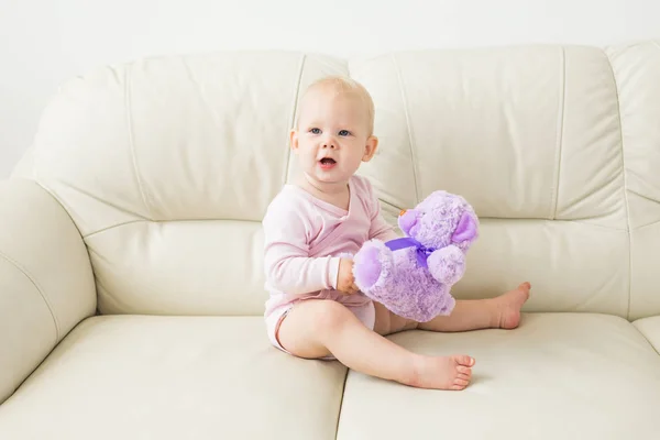 Los niños, el bebé y el concepto de la infancia - Hermoso bebé suave lindo sentado en el sofá — Foto de Stock